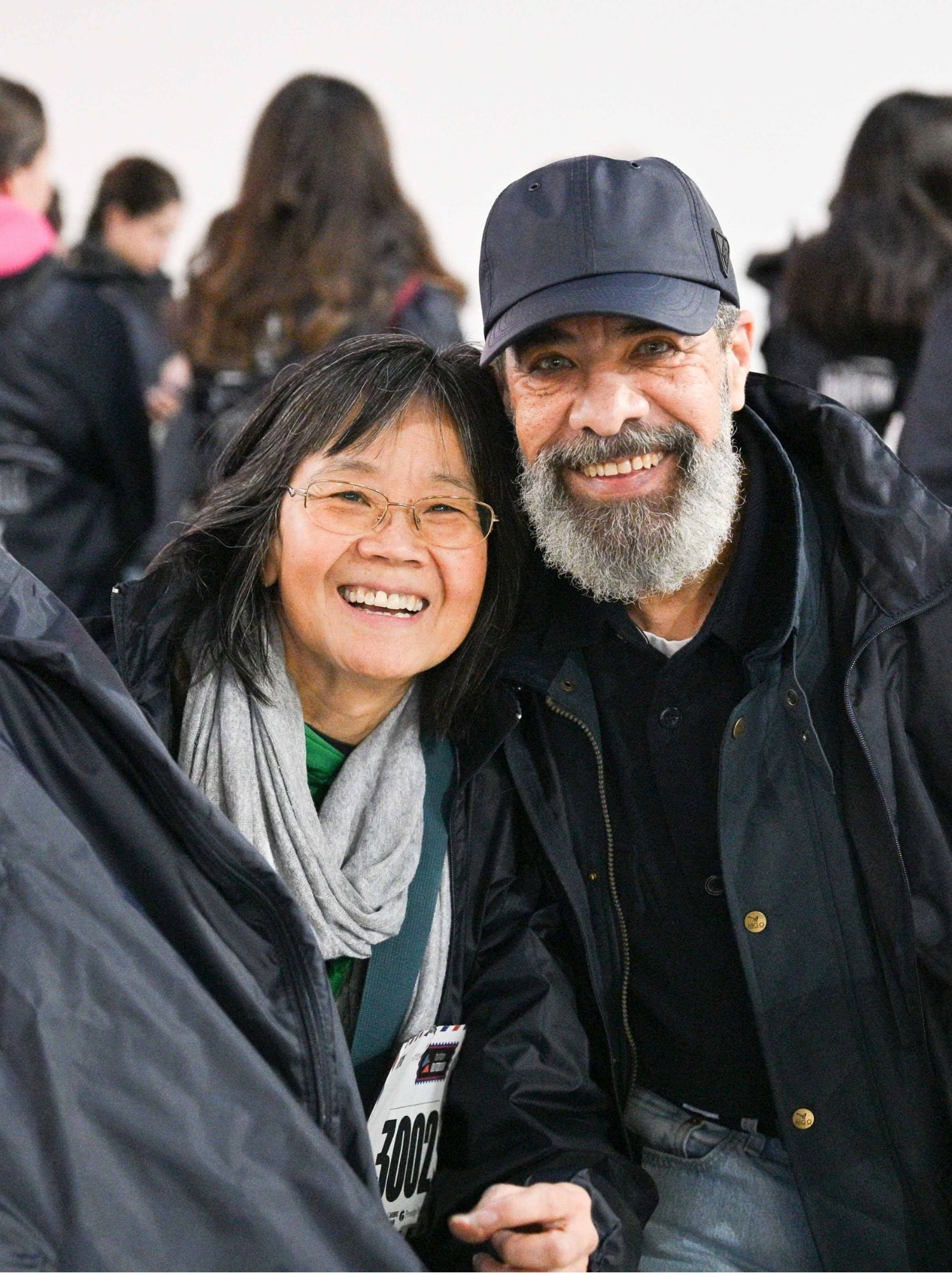 Deux bénévoles souriants au milieu du rassemblement en intérieur