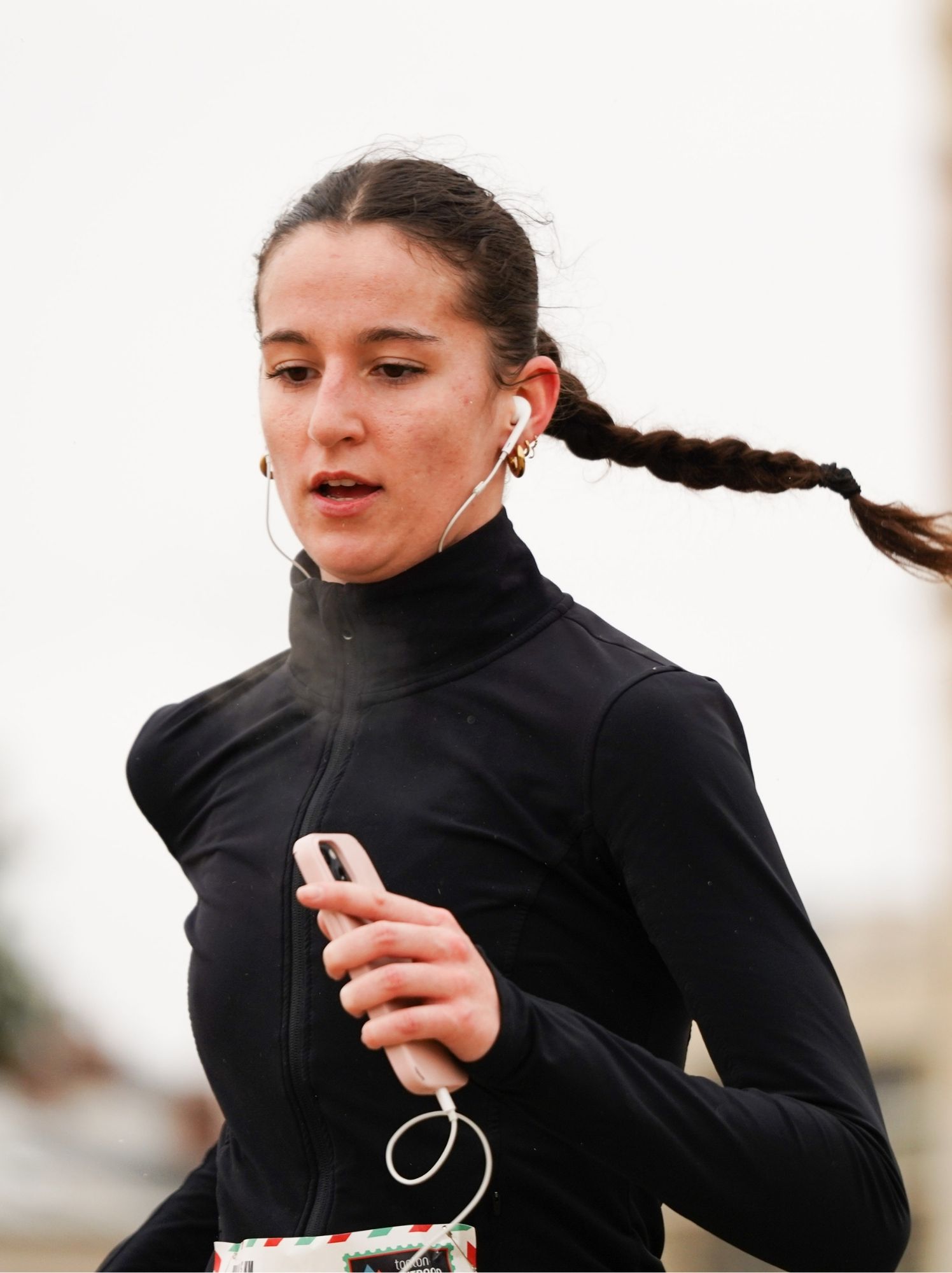 Coureuse à la longue tresse et aux écouteurs, en courant sur un chemin