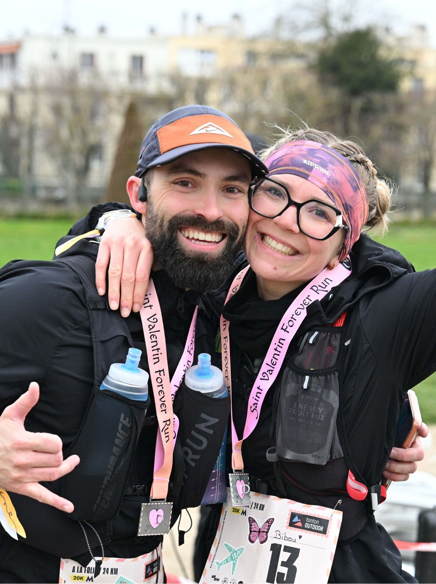 Coureurs finishers enlacés et souriants, médailles autour du cou, sacs d'hydratation